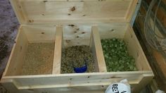 an open wooden box filled with lots of different types of birdseed and seed mixtures