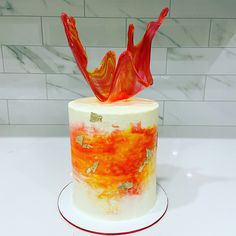 a white cake with orange and red frosting