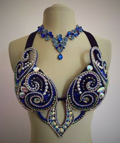 a blue and white beaded halter top on a mannequin