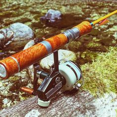 a fishing rod and reel sitting on top of a rock