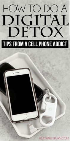 a cell phone sitting on top of a white tray next to a pair of keys