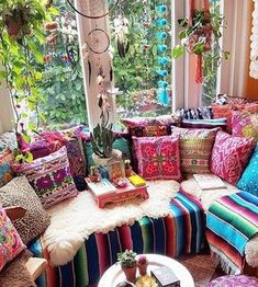 a living room filled with lots of colorful furniture and pillows on top of each other