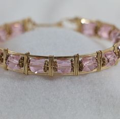 This bracelet is created with Pink Glass beads and wire wrapped.   Bracelet is 7 inches in length and is made of 14kt gold filled wire..   The bracelet comes in a gift box ready for giving to that special someone.... Wow what a great Gift.... Adjustable 14k Gold Filled Wire Wrapped Bracelets, 14k Gold Filled Wire Wrapped Bracelet As Gift, Gold Hand Wrapped Crystal Bangle Bracelet, Gold Wire Wrapped Crystal Bracelet As Gift, Wire Wrapped Bracelet, Gold Wire, Beads And Wire, Pink Glass, 14kt Gold