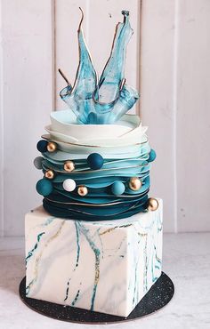 the cake is decorated with blue and white icing on it's top tier