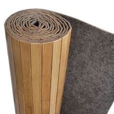 a roll of felt sitting on top of a piece of wood next to a floor mat