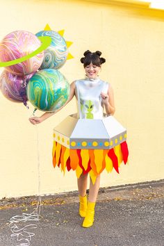 a woman in a costume holding some balloons