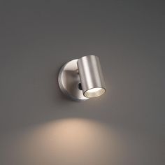 a wall mounted light on the side of a gray wall with a dimmer in front of it