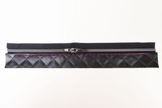 a black purse with pink stitching on it