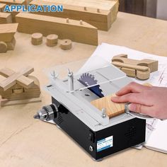 a person is using a machine to make wooden letters with woodworking tools on the table