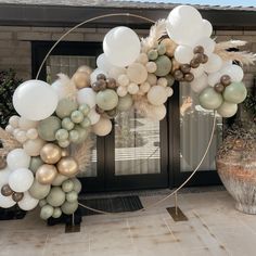 a balloon arch with white and gold balloons