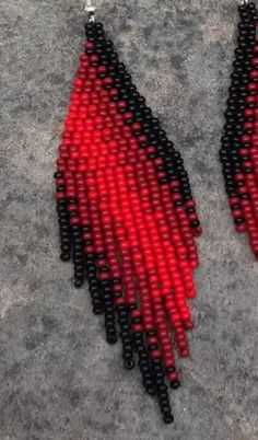 red and black beaded earrings on concrete