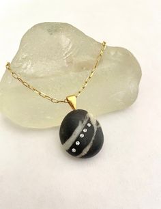 This is a gorgeous Mediterranean pebble with 5 Swarovski crystals embedded set in 24 kt gold plated sterling silver chain and bail.  https://www.etsy.com/es/shop/DinaFlorezSeaGlass ♥ Gold Necklaces With Oval Pendant And Stones, Gold Necklaces With Stone Setting As Gift, Oval Gold Necklaces With Stones, Oval Gold Necklace With Stones, Gold Sterling Silver Necklaces With Stone Setting, Gold Sterling Silver Necklace With Large Stone, Gold Necklaces With Stone Setting In Sterling Silver, Gold Teardrop Pendant With Stones Jewelry, Gold Teardrop Pendant Jewelry With Stones