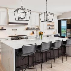 a large kitchen with an island and lots of chairs