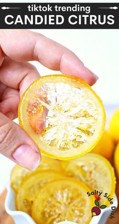 a person holding up a sliced lemon in front of the camera with text overlay that reads tiktok trending candied citrus