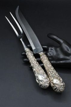 two forks and spoons sitting next to each other on a table with black gloves