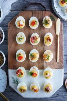 an assortment of deviled eggs on a cutting board