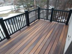 a wooden deck with black rails and railings