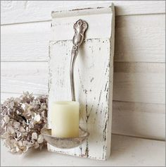 a candle is sitting on a white shelf