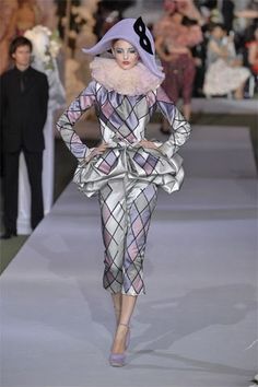 a woman is walking down the runway in a costume