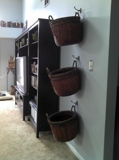 three baskets are hanging on the wall in this living room