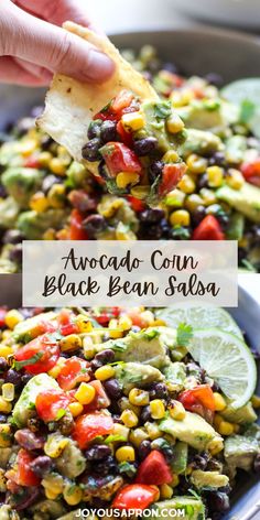 an avocado corn and black bean salsa in a bowl with a tortilla chip