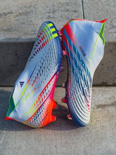 a pair of colorful shoes sitting on top of cement steps in front of a stone wall