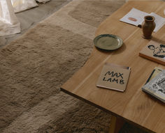 a coffee table with some books on it and a cup sitting on top of it