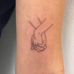 a couple of hands holding each other on the wrist tattoo designs for women and men