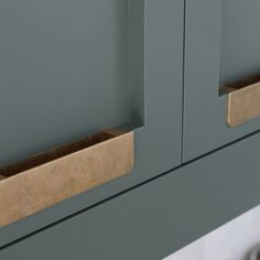 a close up view of the handles on a gray cabinet with two drawers in it