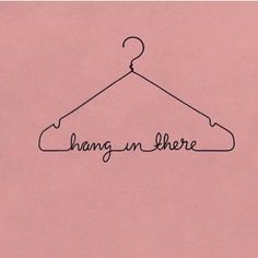 a hanger with the word hang on there written in cursive ink, against a pink background