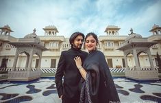 two people standing in front of a building