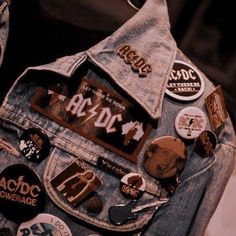 the back pocket of a jean jacket with patches and pins on it's lap