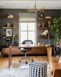 a home office with black walls and wooden furniture