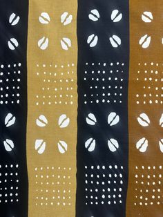 four different colors of fabric with white dots and circles on black, brown, yellow, and tan stripes