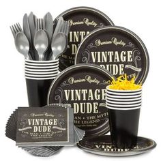 an assortment of black and gold party supplies including plates, cups, napkins and forks