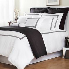 a bed with black and white comforters in a room