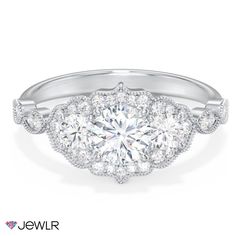 an engagement ring with three stone halos and round diamonds on the sides, in white gold