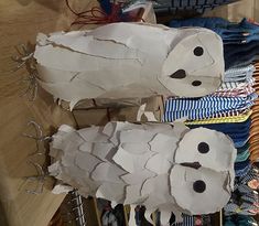 two paper mache sheeps sitting on top of a wooden table next to other items