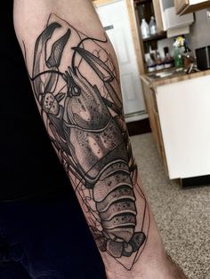 a man's arm with a lobster tattoo on it