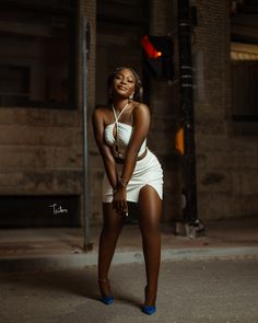 a woman posing for a photo in front of a traffic light with her hands on her hips