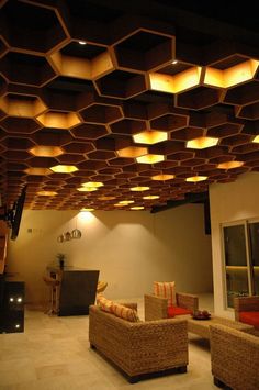 a living room filled with lots of furniture under a wooden ceiling covered in light bulbs