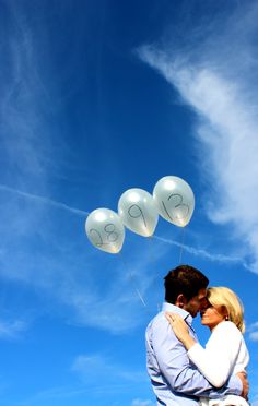 a man and woman are holding balloons in the shape of numbers on their foreheads