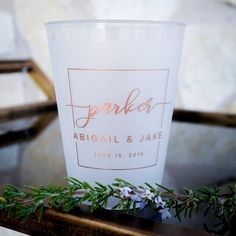 a candle that is sitting on top of a table with flowers and greenery around it