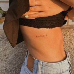 a woman with a small tattoo on her stomach