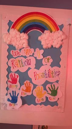 a bulletin board with rainbows and hand prints on it