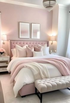 a bedroom with pink walls, white bedding and two lamps on either side of the bed