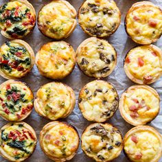 many different types of muffins on a piece of wax paper with toppings