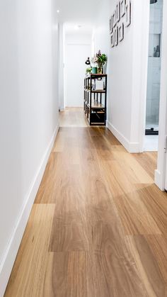 an empty hallway with white walls and wooden floors