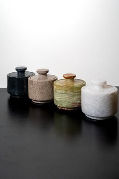 four jars are lined up on a table