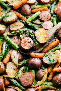 roasted potatoes and asparagus in a pan with a wooden spoon